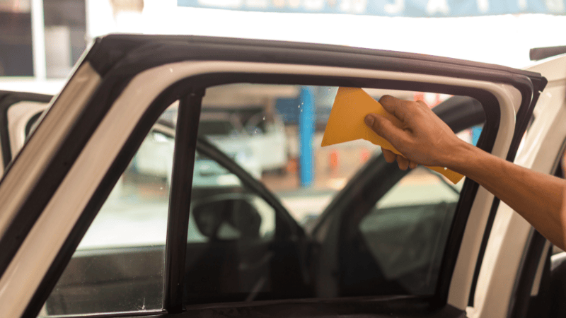 A man is tinting the window tint film.