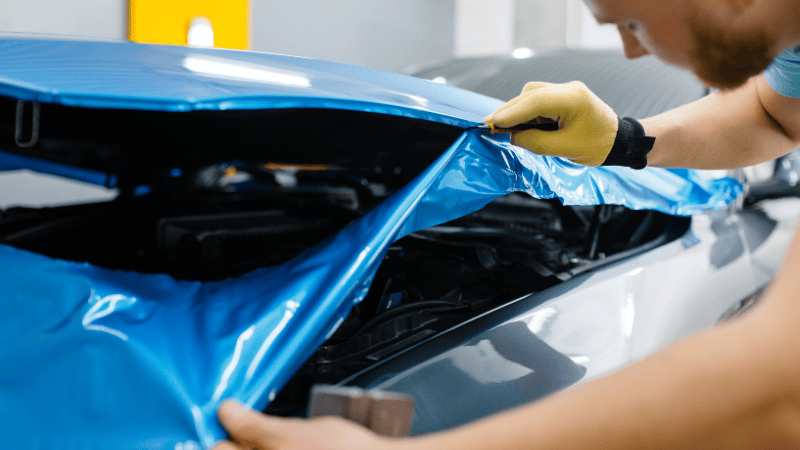 A man is wrapping a car.