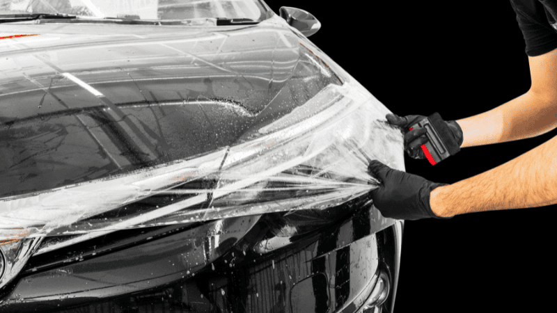 A man is removing the PPF from a car.