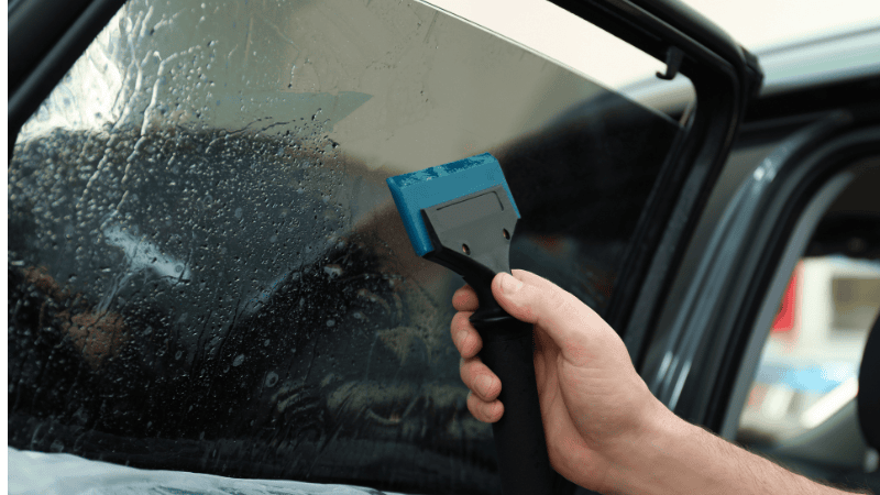 A man is installing a window tint.