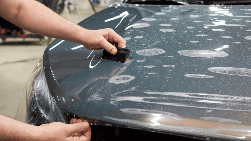 A car undergoing the wrapping process, showcasing the application of a vibrant vinyl wrap for enhanced aesthetics and protection.