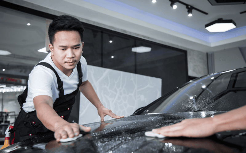 A man is carefully applying car wrap.