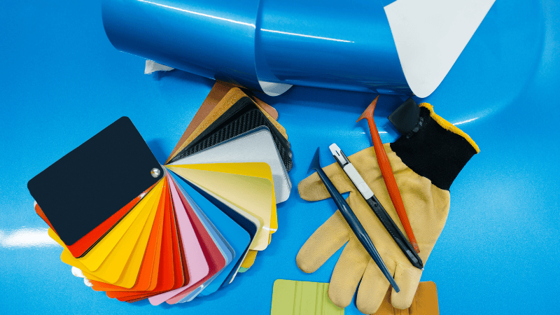 vinyl wraps with different colors, gloves and plastic scraper
