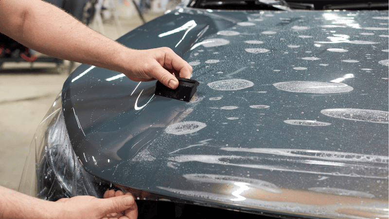 A man is installing a car wrap.