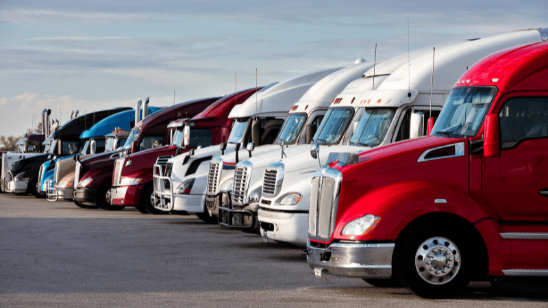 Many colorful trucks are on the road.