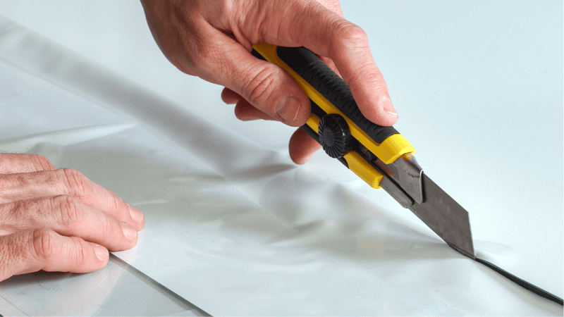 A man is cutting the vinyl wrap.
