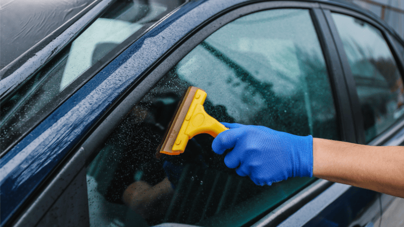 A man is installing a car window tint film.