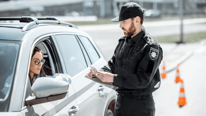A police is checking the car window tint.