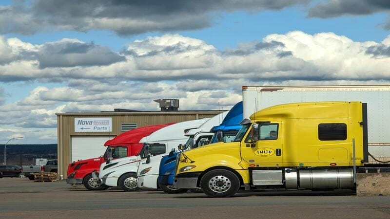 A fleet of trucks parked outside a parts store