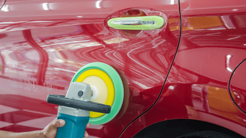 A man is repairing the scratches on the car.