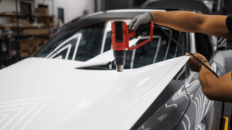 Bir adam ısı tabancası kullanarak sargıyı yerleştiriyor.