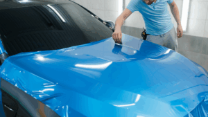 A man is wrapping the car hood.