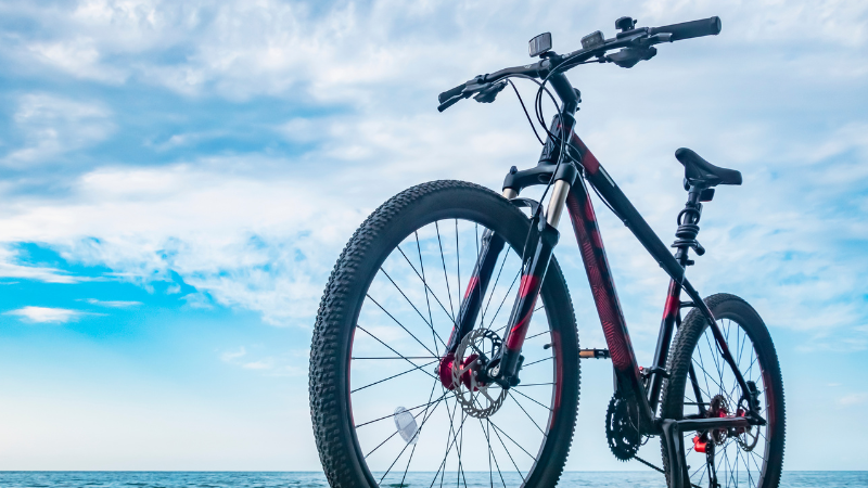 A bike in a vinyl wrap is on the beach.