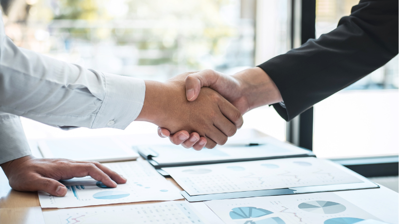 The two business men are shaking hands after making a deal.