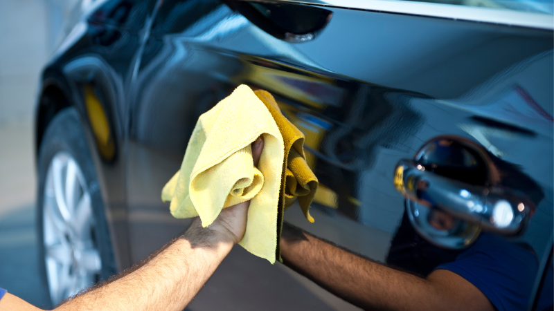 A man is cleaning the car.