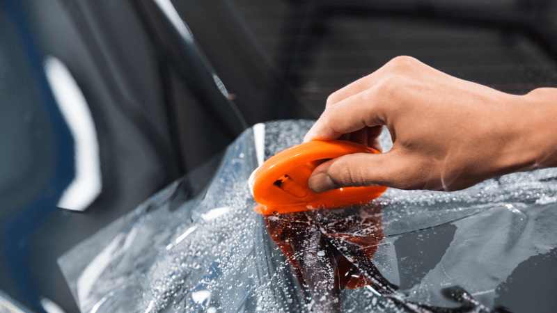 Was applying film to the car and scraping off air bubbles with a squeegee.