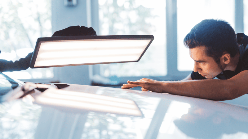 A man is checking the car.