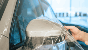 A man is installing ppf on the car