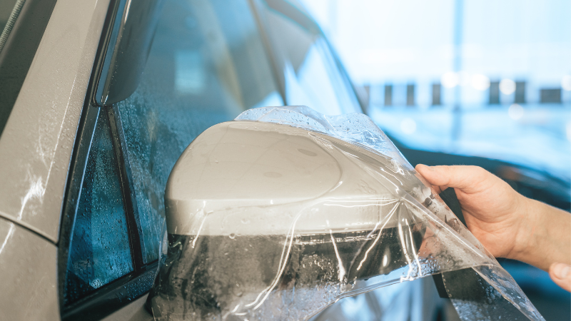 A man is installing ppf on the car