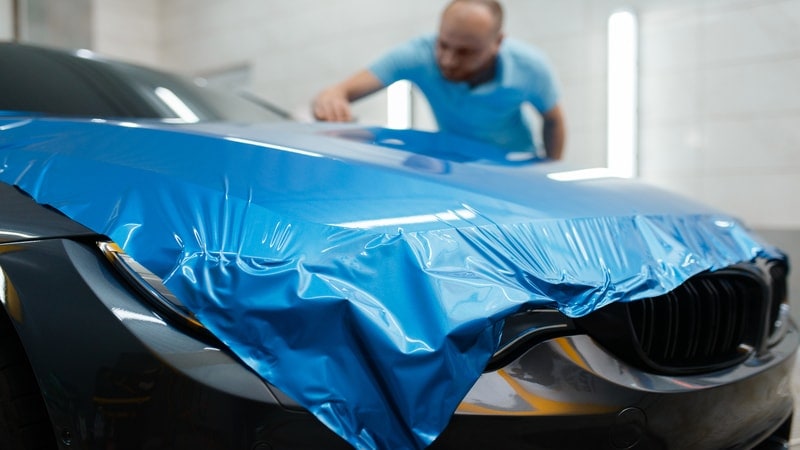 A man is installing the car wraps.