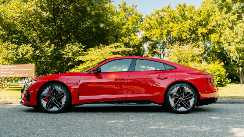 A sports car with red vinyl wrap is on the road