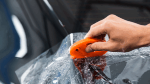 A man is applying the PPF on a car.