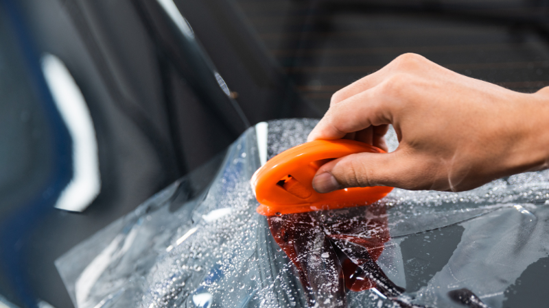 A man is applying the PPF on a car.