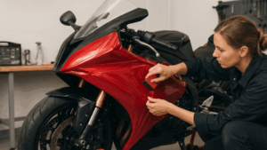 A woman is wrapping a motorcycle.