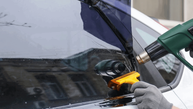 A man is applying ceramic tint.